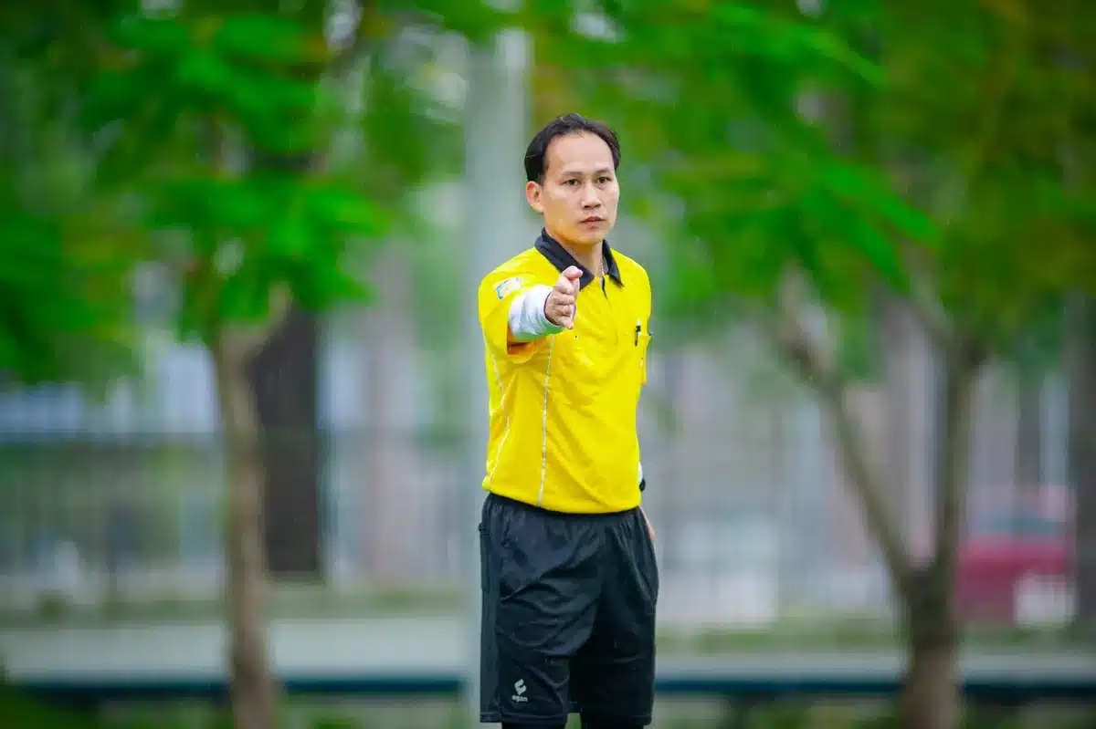 Arbitro durante una decisione in campo con assistenti
