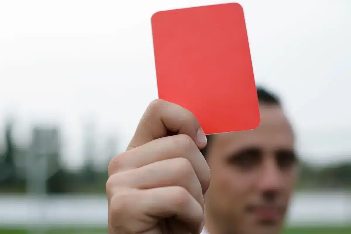 Arbitro e calciatore durante la ripresa del gioco in una partita di Serie A