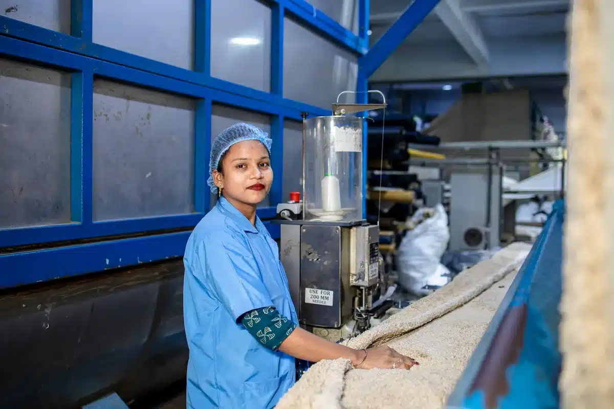 Operai in uno stabilimento di produzione di birra durante una riunione di discussione, con macchinari industriali sullo