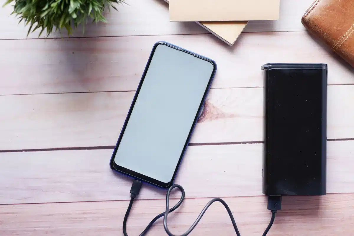 Uno smartphone in ricarica con cavo moderno su una scrivania luminosa