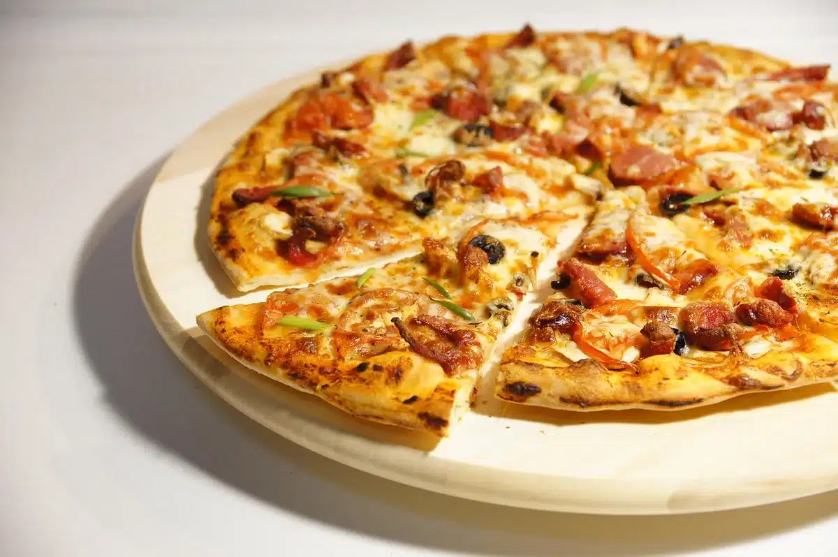 Dettaglio della bambola con grembiule e accessori per la pizza