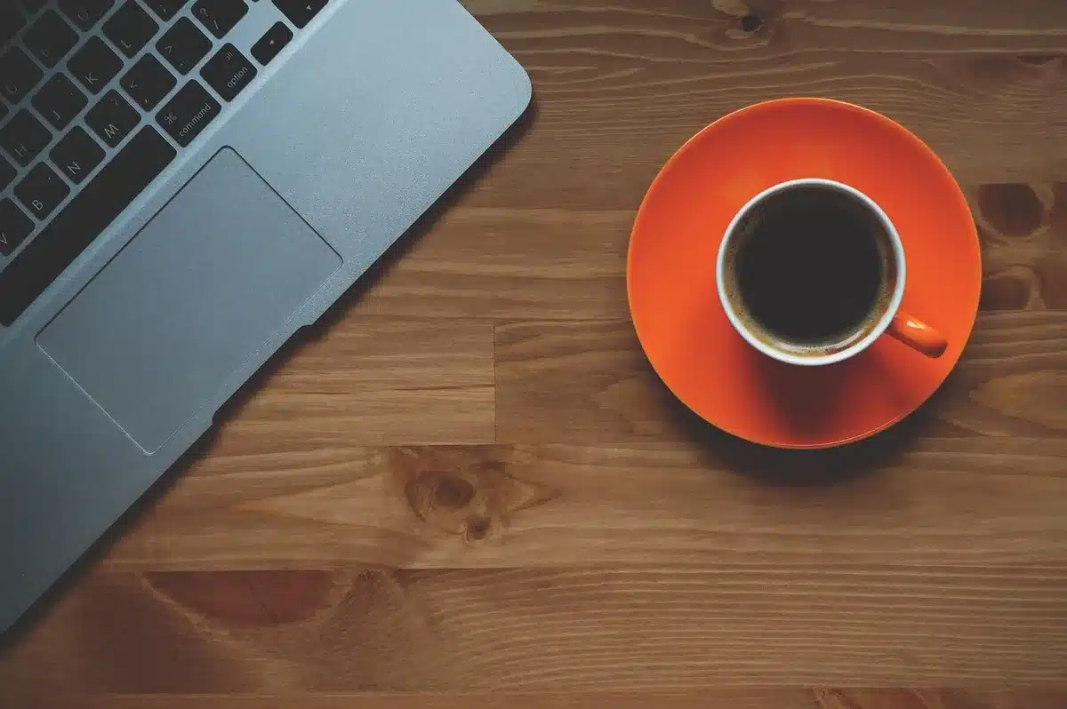 Agenda aperta su una scrivania con una tazza di caffè e appunti di programmazione