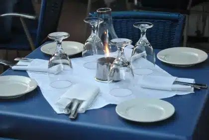 Bancone di ristorante con mani anonime che impiattano piatti, luci calde