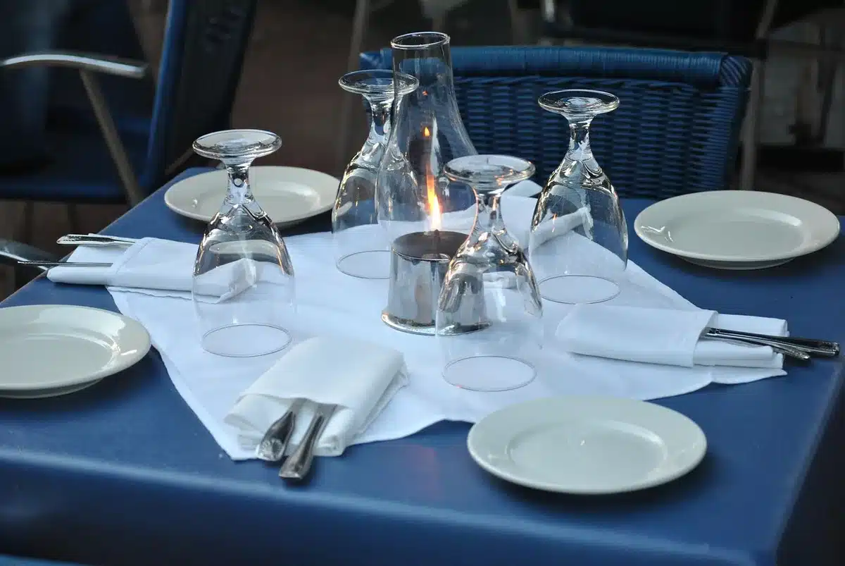 Bancone di ristorante con mani anonime che impiattano piatti, luci calde