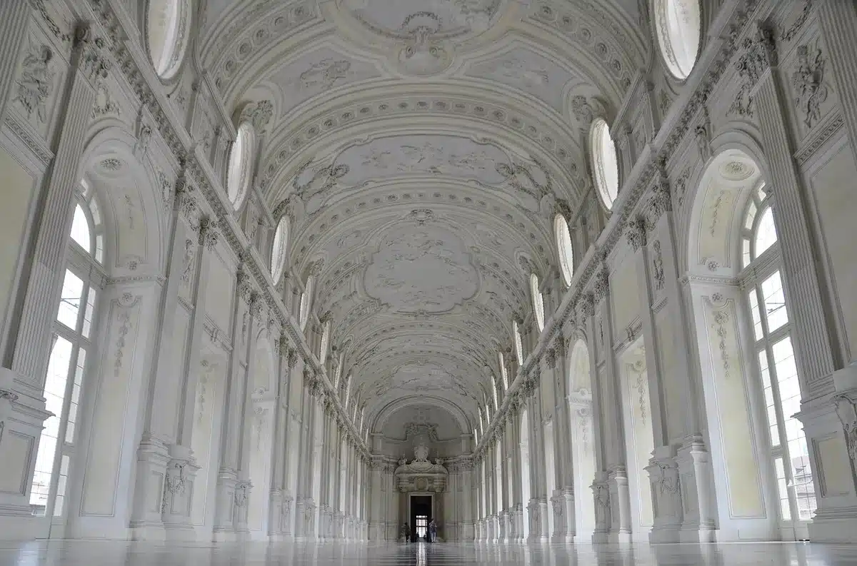 Interno di una galleria vuota con pareti bianche e illuminazione espositiva