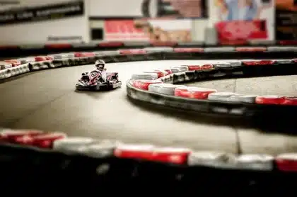 Go-kart in pista durante un evento con pubblico sullo sfondo