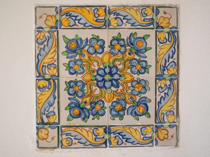 Mani guantate di restauratore al lavoro su un pannello dipinto in uno studio di restauro