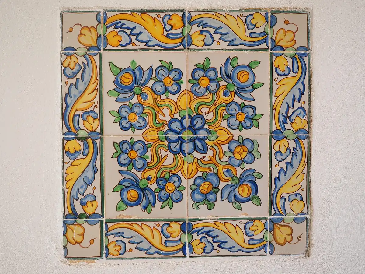 Mani guantate di restauratore al lavoro su un pannello dipinto in uno studio di restauro