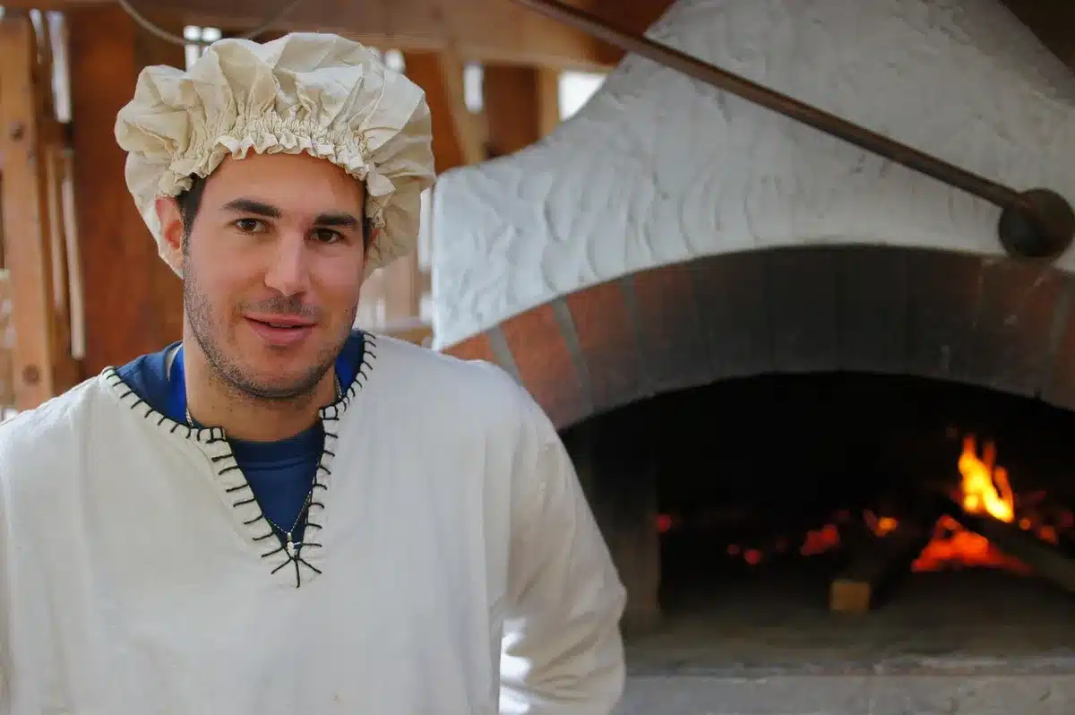 Pizzaioli al lavoro e pizze con ingredienti locali in primo piano